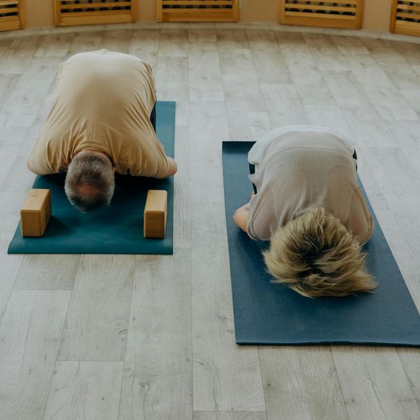 Group of cheerful seniors practicing chair yoga in a bright studio.