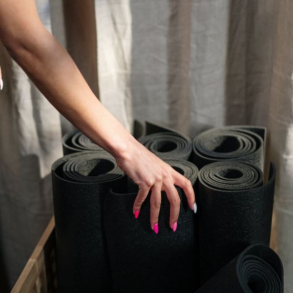 Neatly rolled yoga mats and props ready for a class in a calm studio.