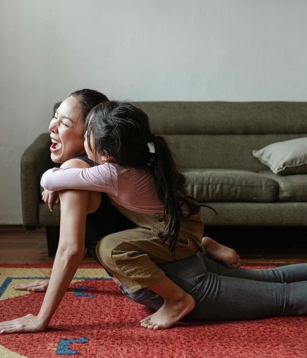 Senior woman smiling peacefully during a gentle yoga stretch at home.